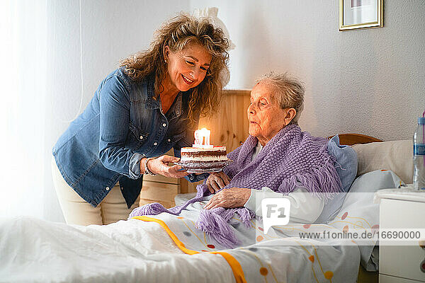 Alte Frau und Tochter feiern ihren 97. Geburtstag mit einer Torte