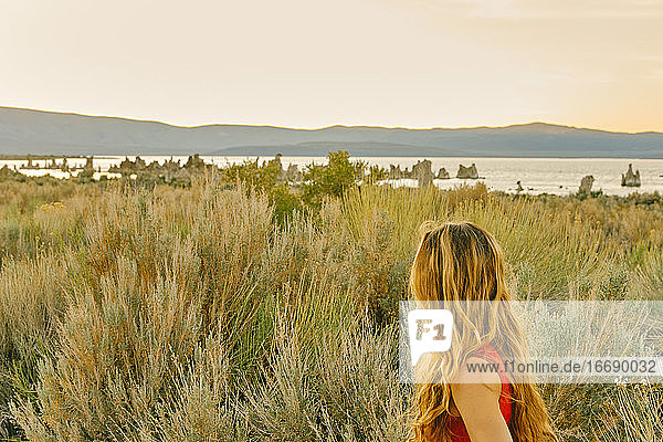 Junge Frau schaut bei Sonnenuntergang zum Mono Lake in Nordkalifornien