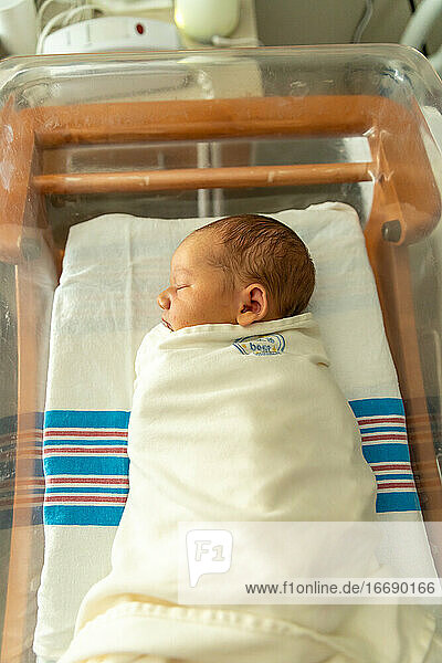 Neugeborenes Baby schläft friedlich im Krankenhauszimmer.