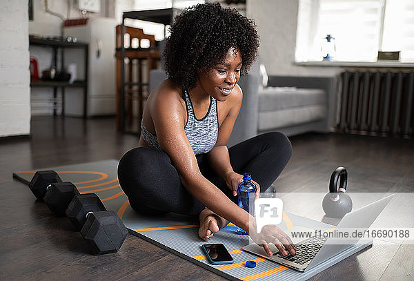 Schwarze Sportlerin benutzt Laptop in der Pause