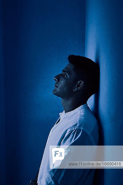 Junger lateinamerikanischer Mann denkt auf blauem Hintergrund