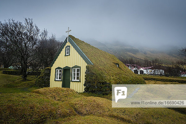 Hofskirkja Kirche gegen den Himmel an einem nebligen Tag im Herbst  Island