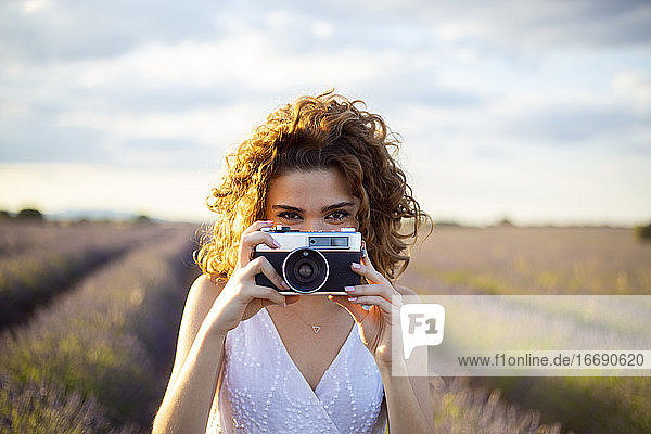 Frau mit Fotoapparat in einem Lavendelfeld