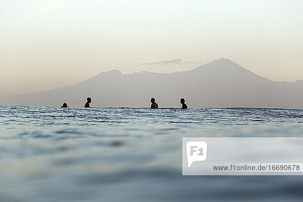 Surfers on surfboard on the sea waiting for a wave  Volcano Rinjani