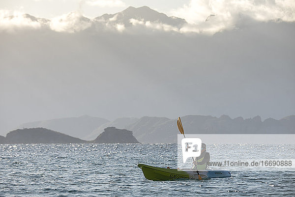 Eine Frau paddelt auf einem Sitz auf dem Kajak in der Nähe des Ufers der Insel Carmen in Loreto  Baja California  Mexiko.