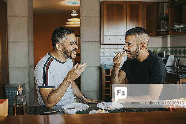 homosexual couple having breakfast together in the kitchen