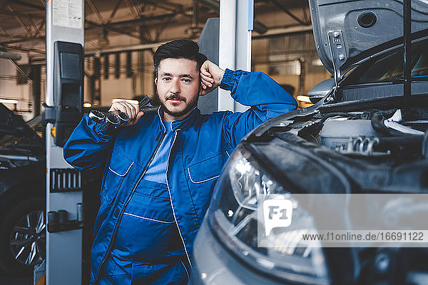 Portrait of a male car mechanic with wrenches