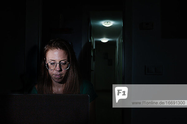 Frau arbeitet nachts mit Laptop