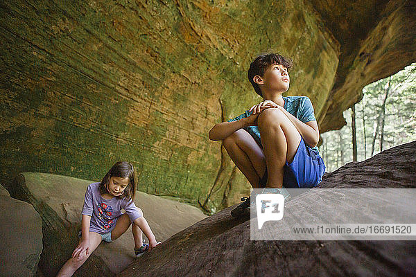 Zwei Kinder spielen zusammen auf einem Felsvorsprung in einer Sandsteinschlucht