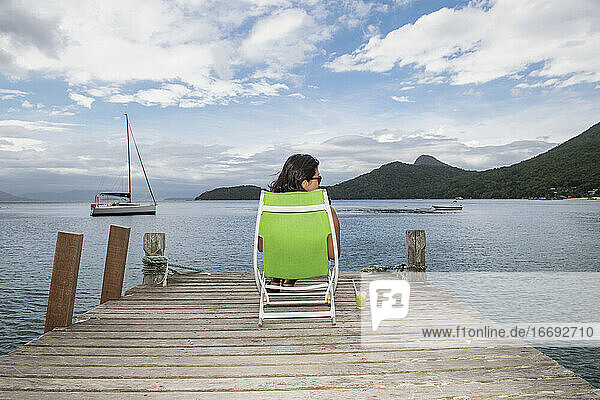 Frau entspannt sich am Pier auf der tropischen Insel Ilha Grande
