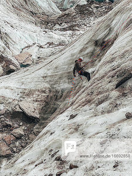 Climber rappelling into crevasses on Mer de Glace glacier in Chamonix