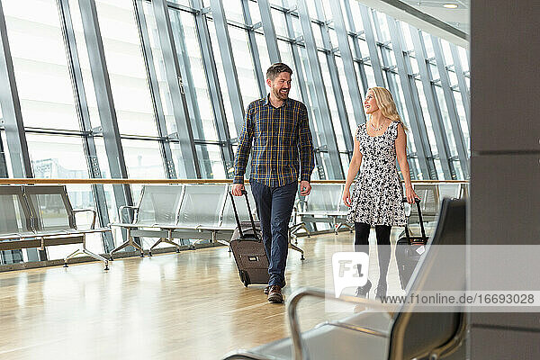 Reisendes Paar mit Koffern auf dem Flughafenflur