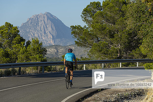 Ein Mann fährt mit dem Fahrrad auf einer Bergstraße an der Costa Blanca