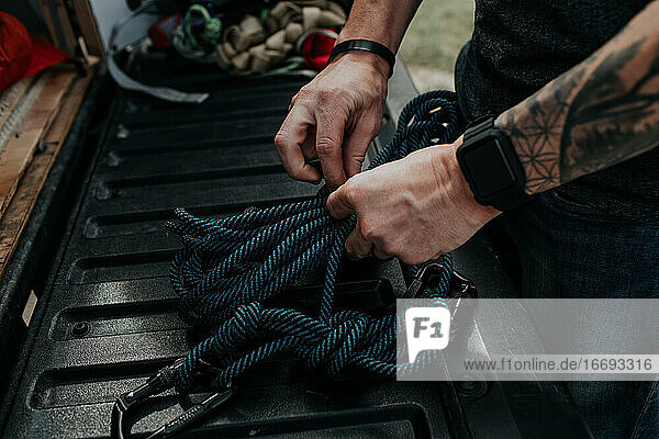 Close up of man prepping climbing ropes