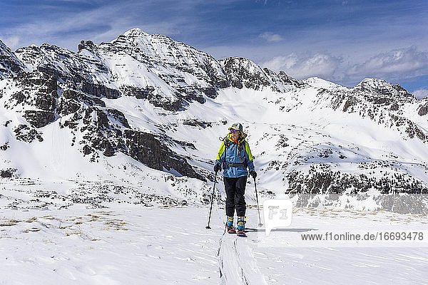Wanderin beim Splitboarding gegen schneebedeckten Berg