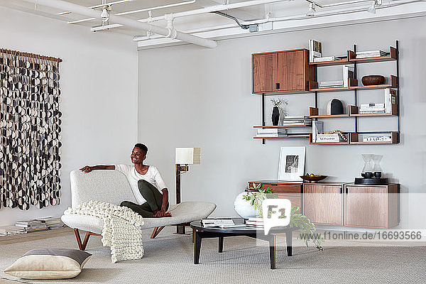 Model in clean  modern livingroom with shelving