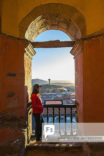 Touristin blickt vom Torbogen über die Dächer von Potosi  Bolivien