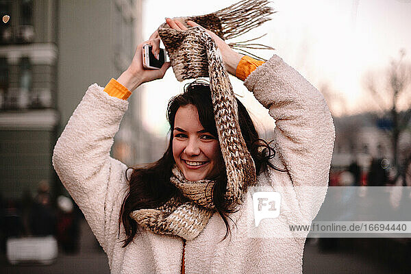 Porträt eines glücklichen Teenagers in warmer Kleidung in der Stadt stehend