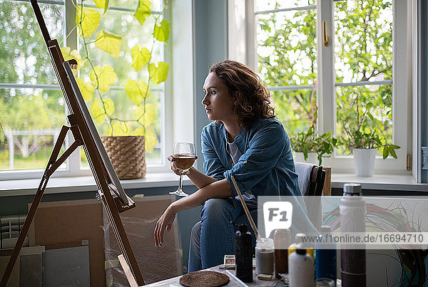 Frau mit Wein bewundert Gemälde