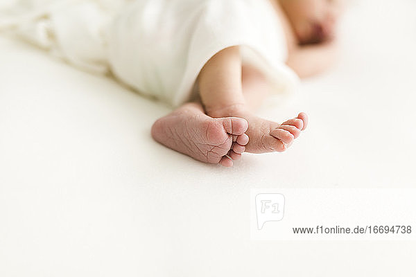 Neugeborene Füße Nahaufnahme auf weißem Tuch