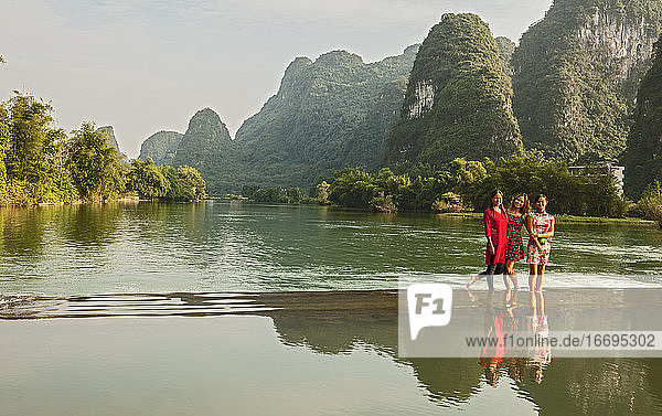 drei schöne Frauen stehen im Fluss Li in der Nähe von Yangshuo