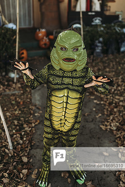 Young boy dressed as sea monster posing in costume at Halloween