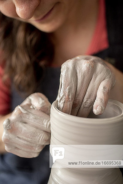 Nahaufnahme von Händen bei der Arbeit an Keramiken