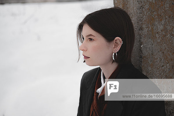 Young attractive woman in leather jacket in snowy background  mi