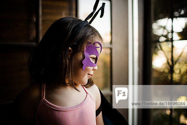 Young girl in dress up looking out front door