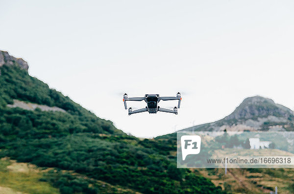 Fliegende Drohne mit Kamera in den Bergen