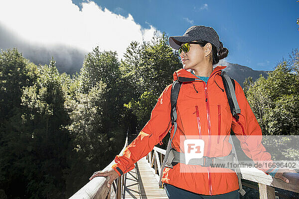Woman crossing wooden bridge at Caleta Gonzalo in Chile