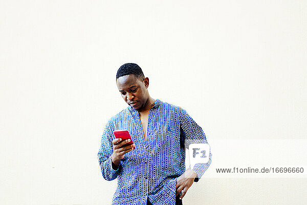 junger afrikanischer Mann benutzt sein Smartphone