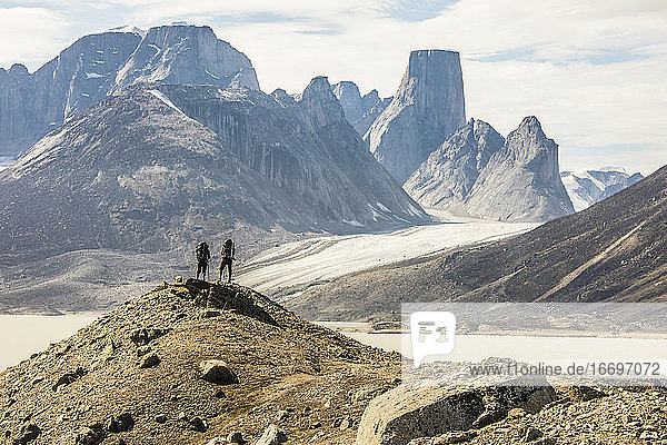 Rückansicht von Wanderern mit Blick auf den dramatischen Bergblick vom Gipfel.