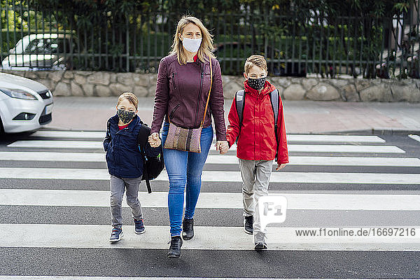 Mutter  die mit ihrem Sohn die Straße überquert