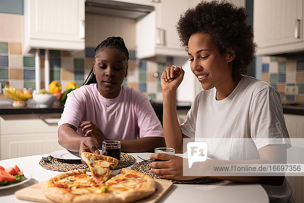 Gemischtrassige Frauen essen gemeinsam Pizza
