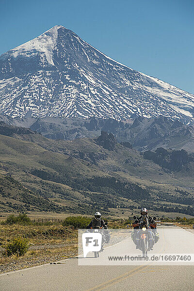 Couple on touring motorbikes. Lanin volcano in the back  Argentina