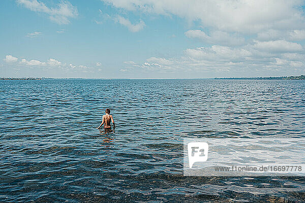 Ein kleiner Junge watet an einem Sommertag im Ontariosee.