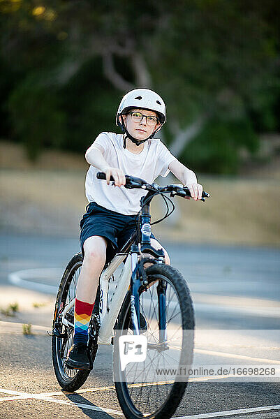 Tween riding mountain bike outdoors on summer day wearing shorts