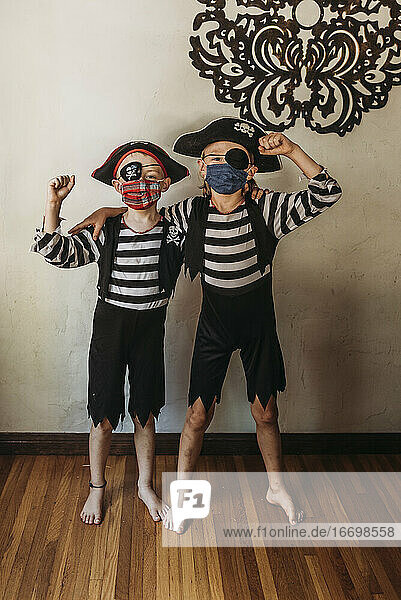 Brüder im Schulalter als Piraten verkleidet mit Gesichtsmasken zu Hause