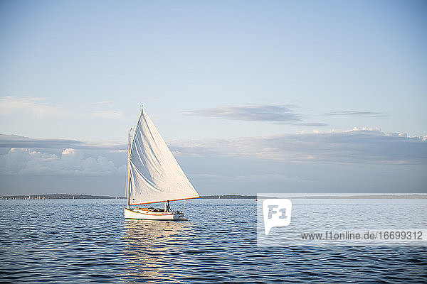 Single ein Katboot Segelboot Segeln während der goldenen Stunde Sommer Sonnenuntergang