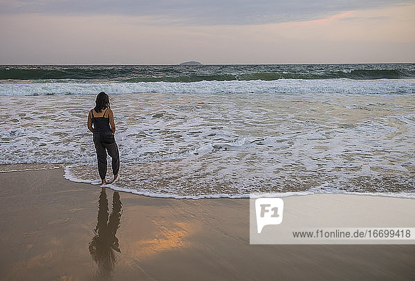 Frau  die ihre Zehen in den Atlantik in Rio de Janeiro streckt