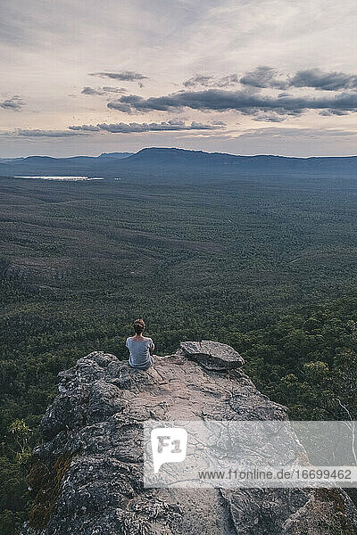 Junge Frau sitzt auf den Balkonen und bewundert die weite Landschaft des Grampians National Park  Victoria  Australien