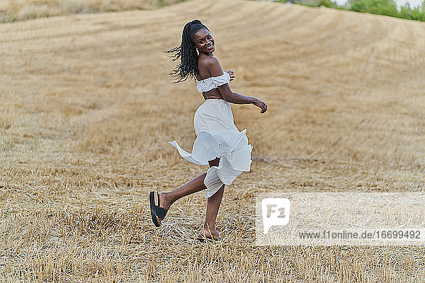 Photo session of a beautiful and happy black woman in a wheat field