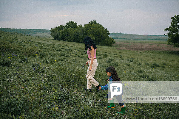 Mother and daughter walking outdoors in countryside
