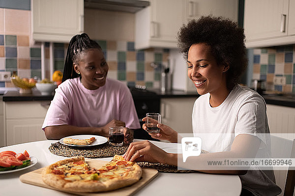 Ethnische Frau genießt Pizza mit Freund
