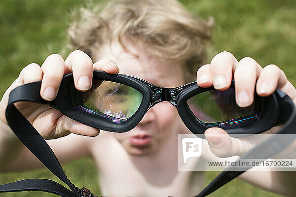 Unscharfer kleiner Junge blickt durch eine scharfe Brille