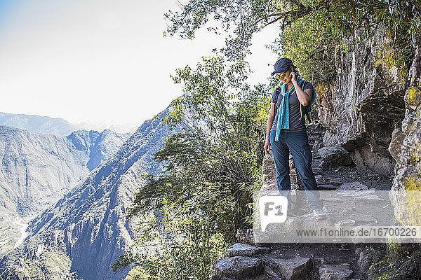 Frau schaut vom Inkapfad in der Nähe von Machu Picchu hinunter