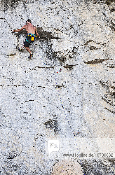 man climbing rock face in Yangshuo