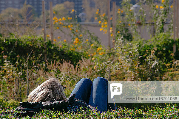 Junge Frau entspannt sich an einem sonnigen Tag in einem Park in Brooklyn  New York