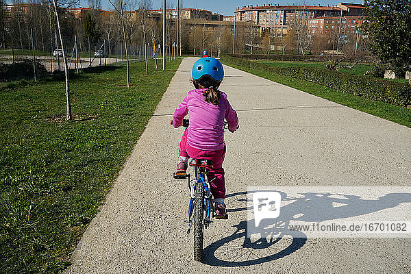 Girl riding a bike seen from behind